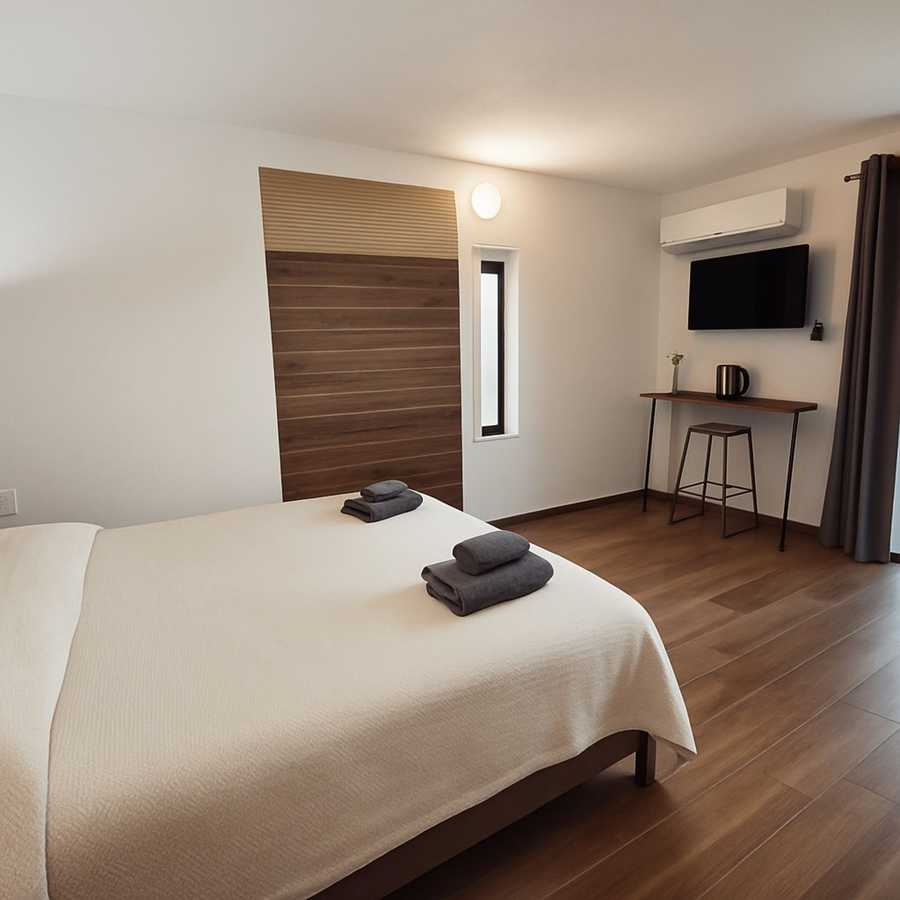Interno camera TERA Rooms Cagliari con legno e lino